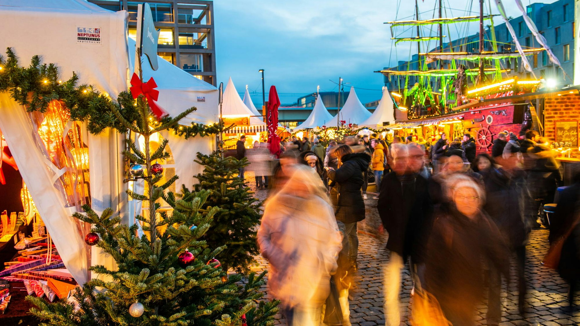 Menschen spazieren über den Hafenweihnachtsmarkt in Köln.