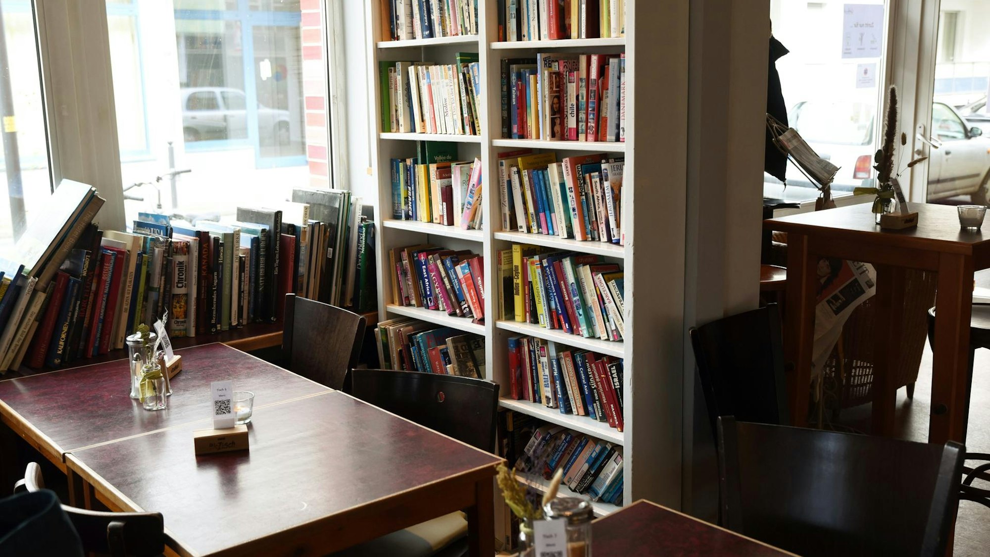 Das Café Goldmund von innen mit Bücherschränken, Büchern auf der Fensterbank und Holztischen