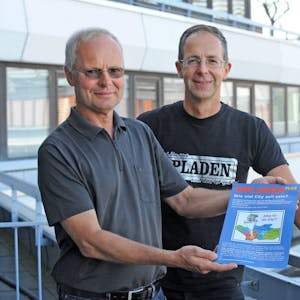 Markus Pott (l.) und Oliver Faber mit dem Flyer von Opladen plus, der an alle Haushalte verteilt wird.