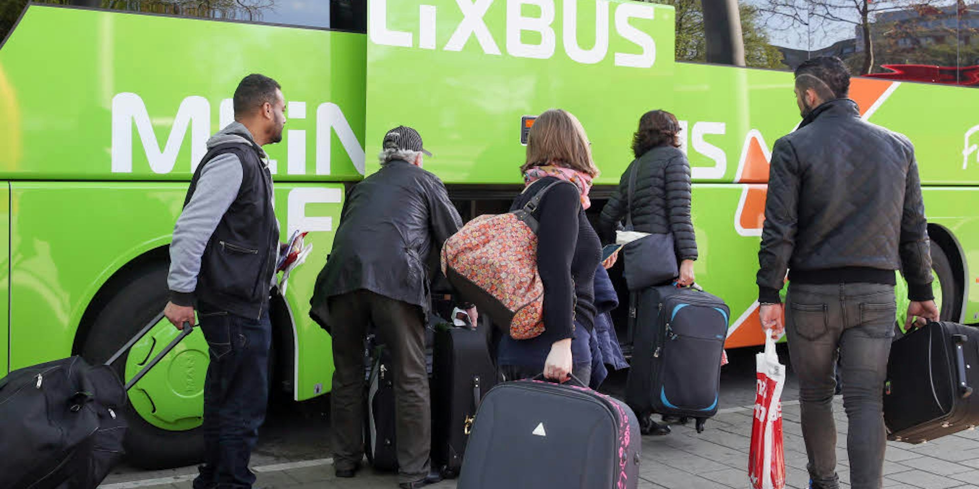 Reisende steigen in einen Flixbus.
