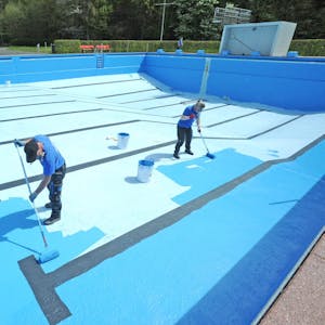 Die Vorbereitungen für die Freibad-Saison laufen: Das Schwimmbecken am Schulbusch wird blau gestrichen.