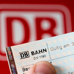 Ein Fahrschein vor einem Fahrkartenautomat der Deutschen Bahn.