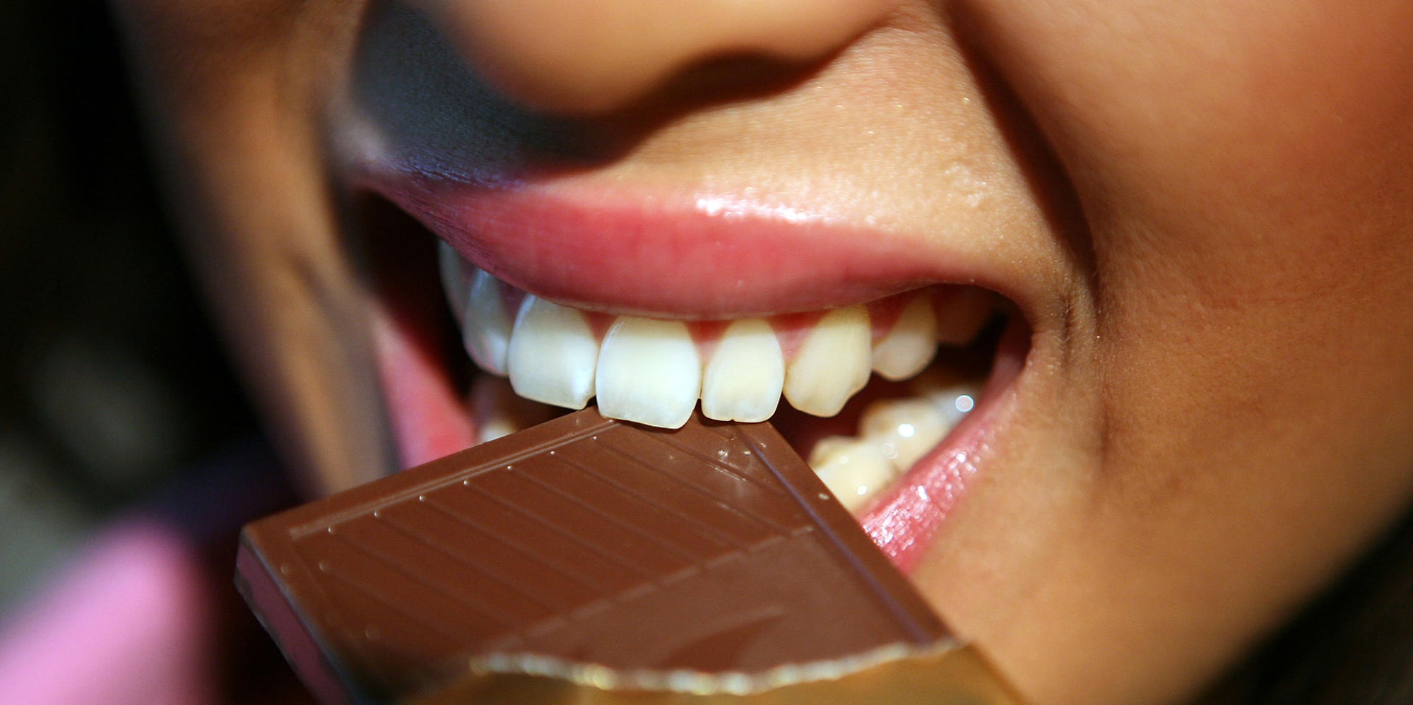 Frau beisst in Schokolade Süßigkeit