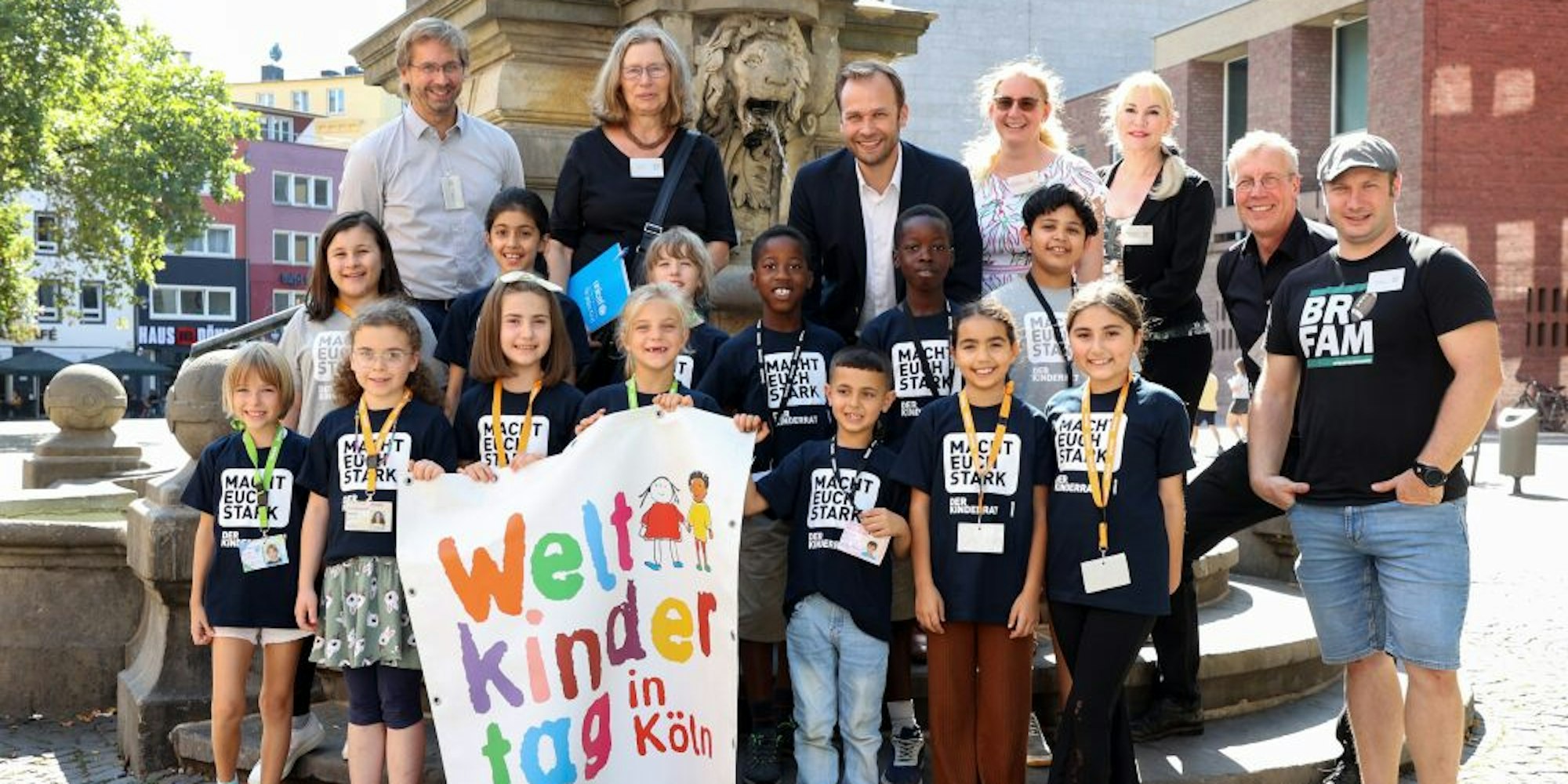 Der Kinderrat der Grundschule Merianstraße präsentiert das Programm des Kölner Weltkindertags gemeinsam mit Vertreterinnen und Vertretern der Veranstalter.