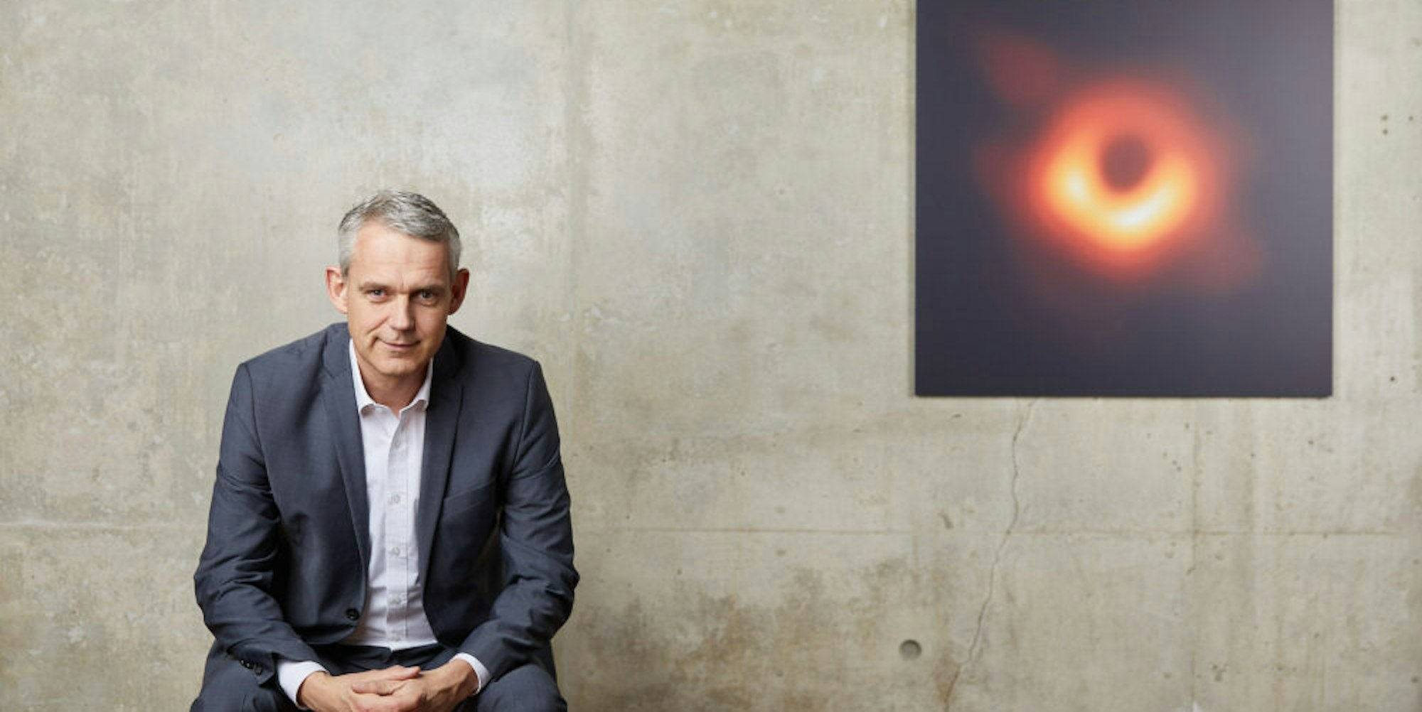 Der in Frechen lebende Astronom Heino Falcke vor dem Bild eines Schwarzen Lochs, das 2019 für eine Weltsensation sorgte.