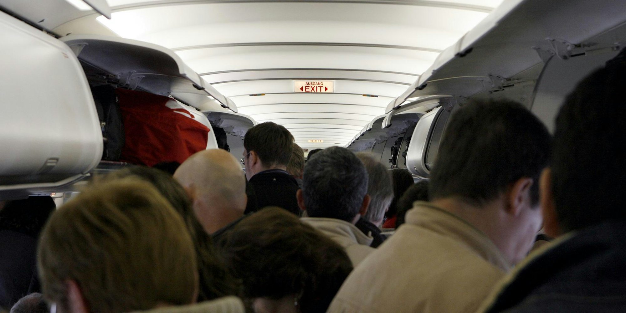 Passagiere stehen im Gang eines Flugzeuges