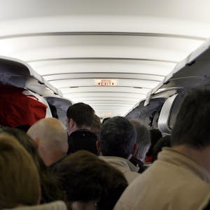 Passagiere stehen im Gang eines Flugzeuges