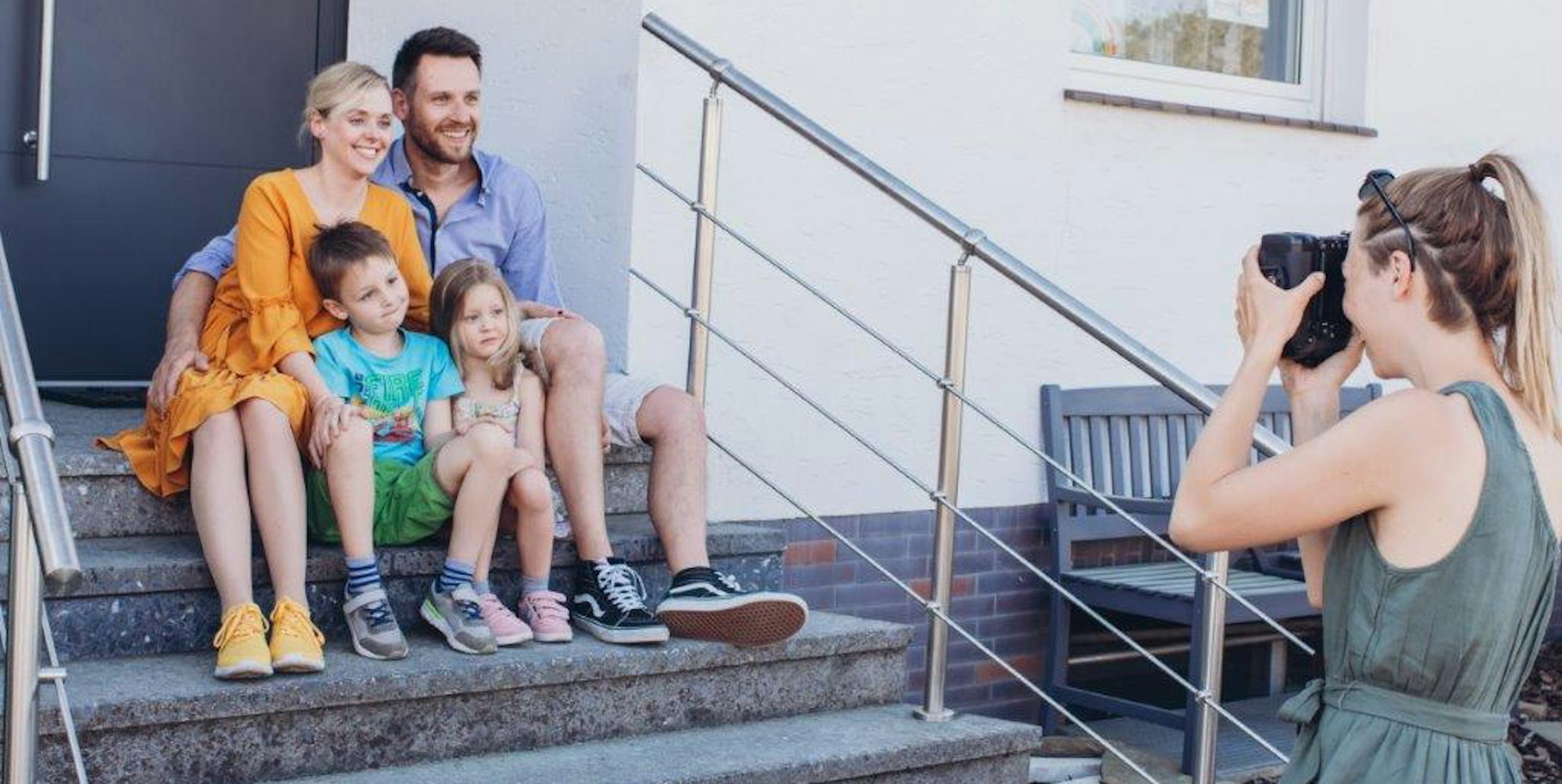 Als Hintergrund ist immer die Tür, der Hauseingang, zu sehen: Anna Zeller beim Corona-Foto-Shooting mit einer Familie.