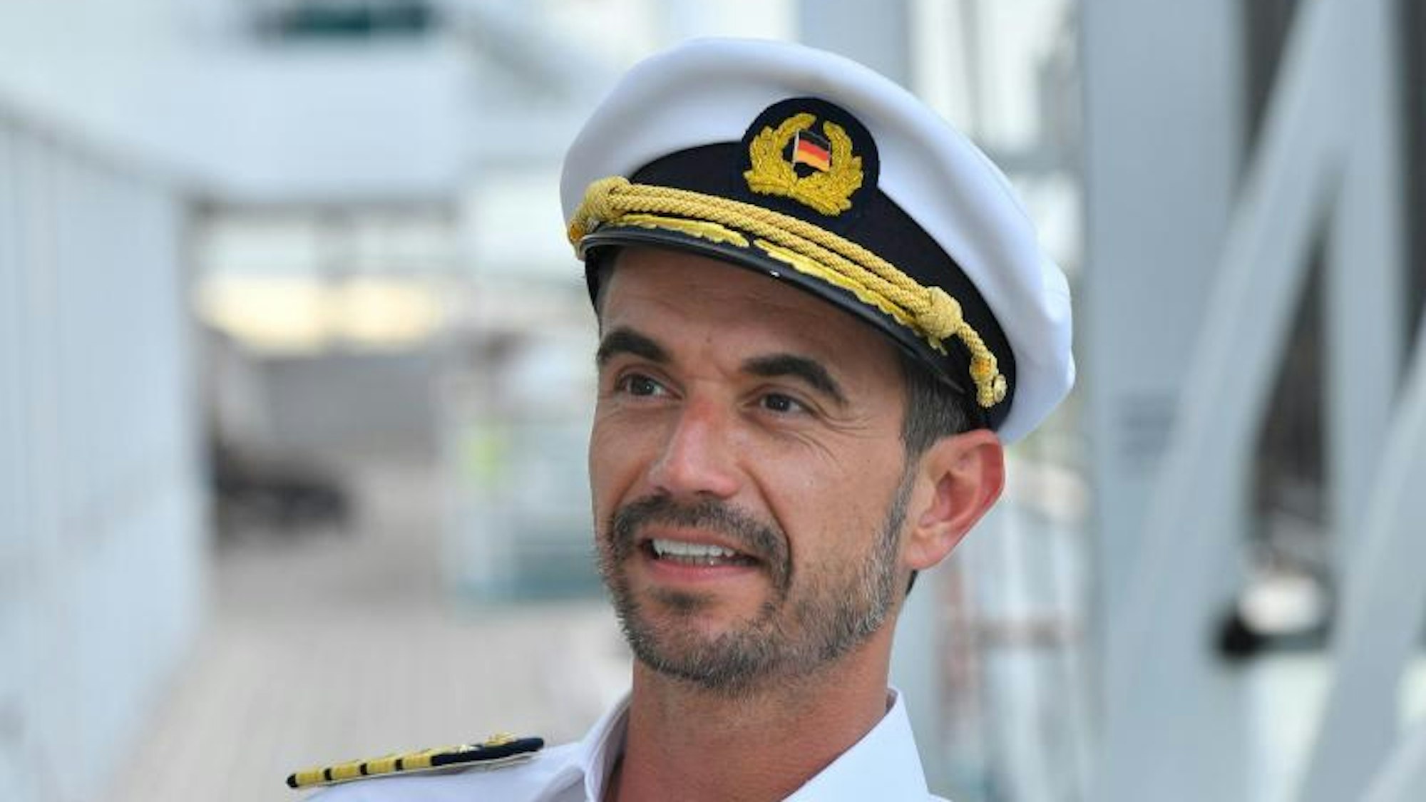 Florian Silbereisen steht in einer Kapitänsuniform auf dem Deck.