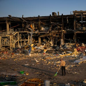 Zerstörung in Odessa: Ein Mann beseitigt Trümmer, nachdem ein russisches Geschoss ein Einkaufszentrum getroffen hat.