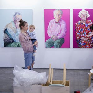 Janina Christine Brügel mit Sohn beim Hängen ihrer Portraits aus der Serie „Age“
