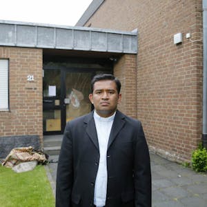 Der Rondorfer Pfarrer Regamy Thillainathan vor der zerstörten Wohnung im Pfarrheim, in der eine Familie aus dem Irak lebte.