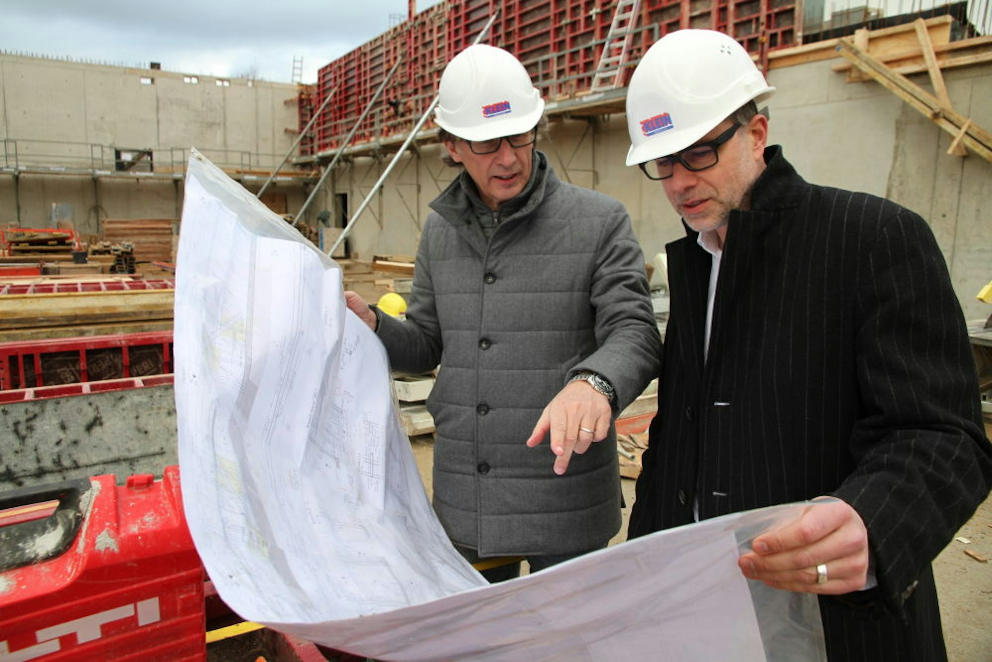 Stadtbetriebe-Vorstand André Kuchheuser (links) und Frank Baake, Direktor der Rhein-Sieg-Halle, sehen sich auf der Baustelle für die Erweiterung um. Der Rohbau soll im März fertig werden.