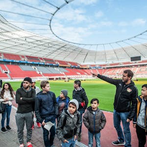 „Da oben sind die Kameras für die Torlinientechnik installiert“, erklärt Stadionführer Michael Niggemeier den Flüchtlingskindern.