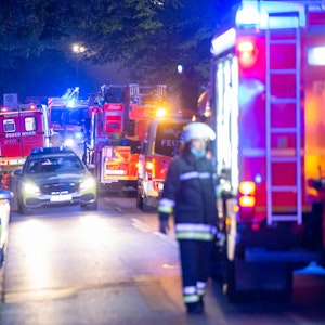 Einsatzfahrzeuge von Polizei, Feuerwehr und Rettungsdienst stehen in der Nacht an und auf einer Straße.