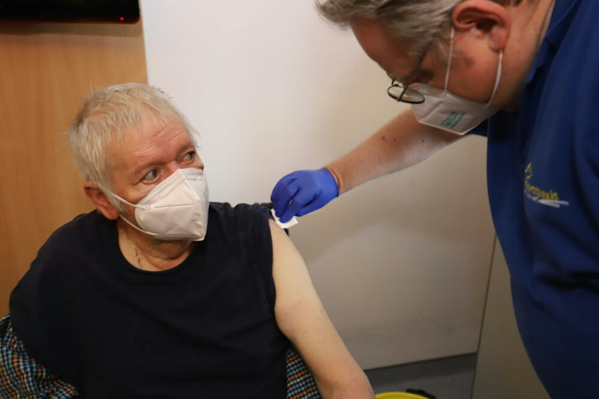 Mit einer kühlen Desinfektion bereitet Arzt Frank Gummelt Helmut Grohn auf seine Impfung vor. In drei Wochen wird der 80-Jährige die zweite Dosis des Biontech-Vakzins erhalten.
