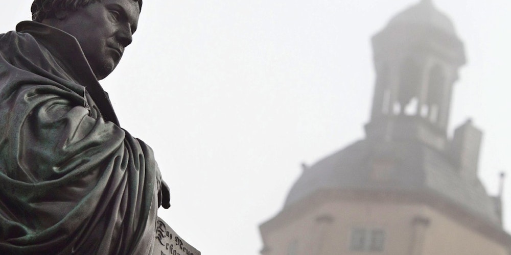 Symbolbild Religion: Das gusseiserne Denkmal für den deutschen Reformator Martin Luther (1483-1546) auf dem Marktplatz der Lutherstadt Wittenberg.