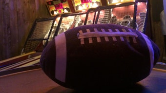 Ein Football liegt auf einem Tisch, im Hintergrund stehen drei Skee-Ball-Bahnen in der Red Fox bar in Ehrenfeld.