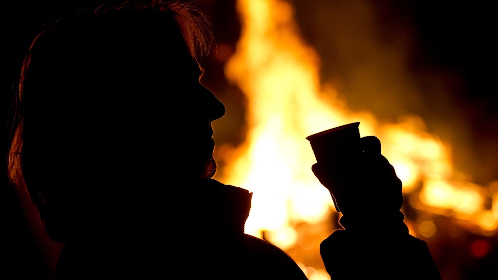Die Silhouette eines Menschen setzt sich auf diesem undatierten Foto vor einem Feuer ab.