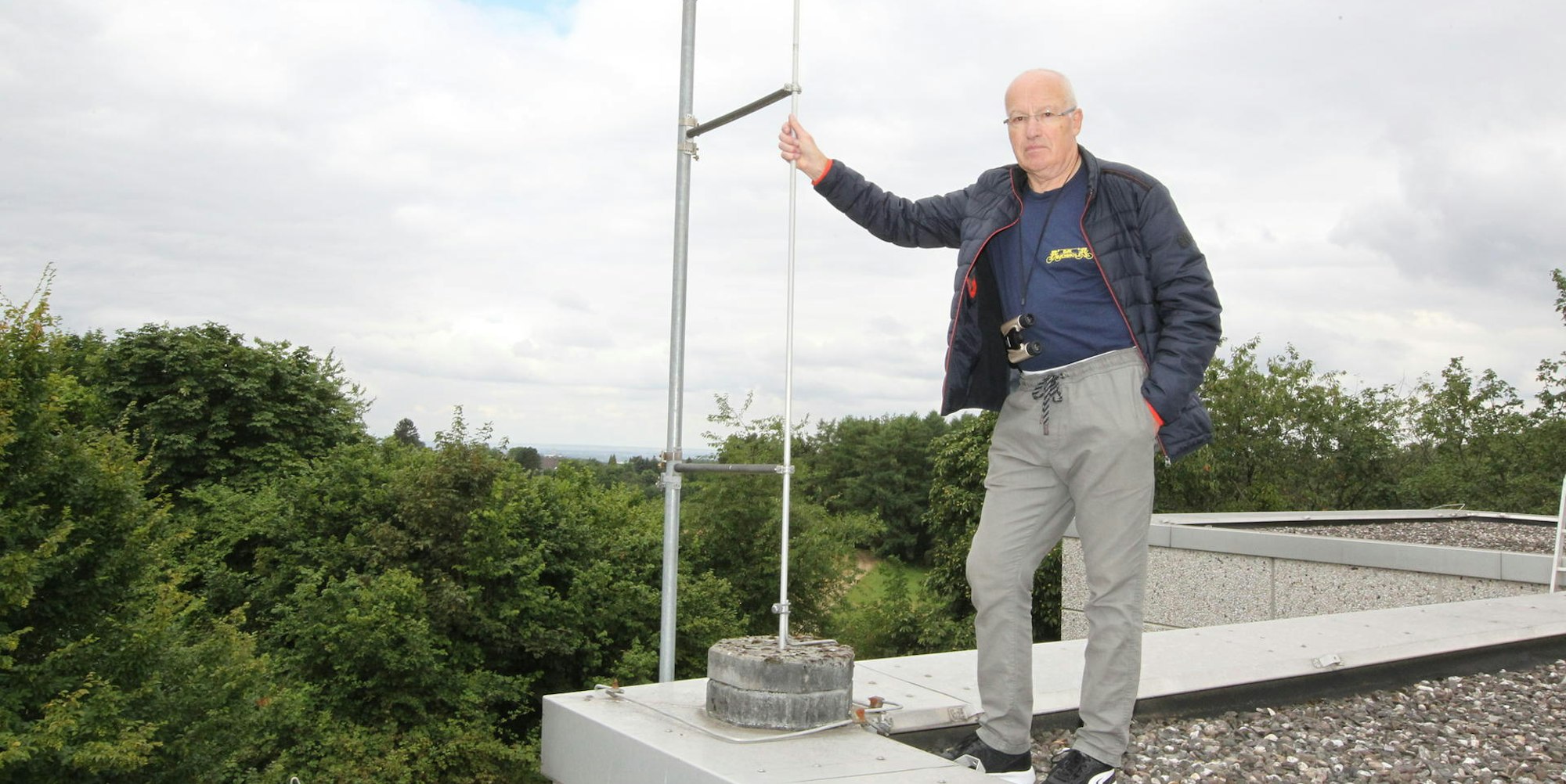 Auf dem Dach der Grundschule Hennef-Happerschoß kontrolliert Helmut Schumacher ein Fluglärm-Messgerät.