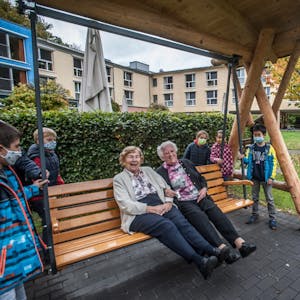 Maria Meis (l.) und Lisa Harms beim Probesitzen auf der Seniorenschaukel mit Kindern der Grundschule Kirchstraße.