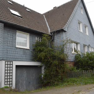 In Morsbach-Steimelhagen steht ein großes Haus, dessen Großteil der Fassade mit grauen Schieferplatten verkleidet ist.