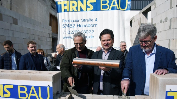 Andreas Zurek, Bürgermeister Ulrich Stücker und Bauausschussvorsitzender Werner Nohl mauerten die Kapsel ein.