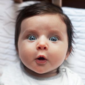 Ein Baby guckt staunend.