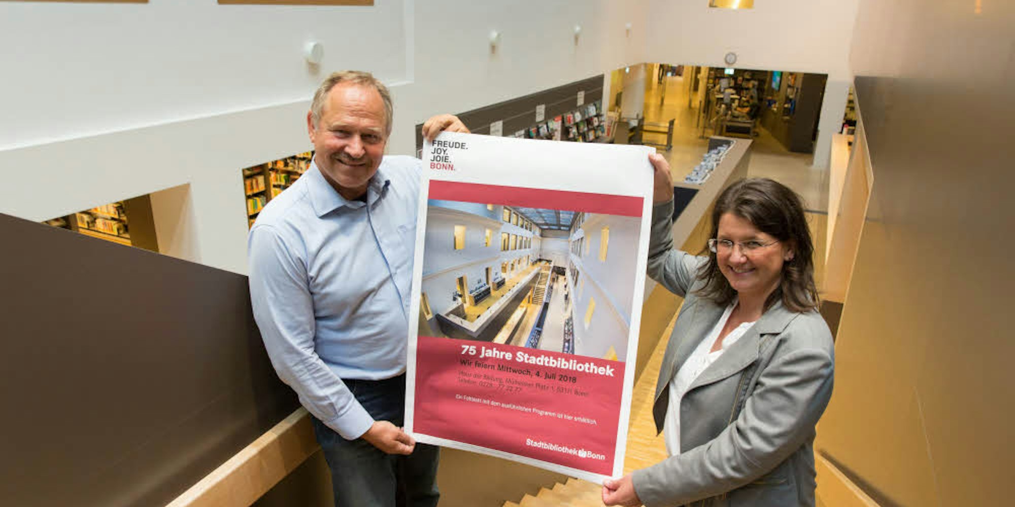 Hereinspaziert! Stadtbibliotheksleiterin Helga Albrecht und ihr Stellvertreter Detlev Lehmann präsentieren das Jubiläums-Plakat.