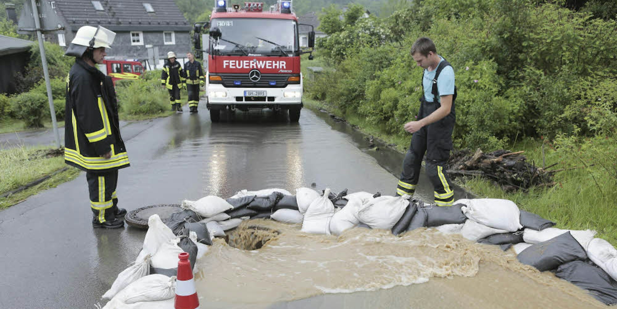 In Welzen bei Hommerich errichte die Feuerwehr Barrieren aus Sandsäcken, nachdem ein Regenrückhaltebecken übergelaufen war und das Wasser über die Straße lief. 