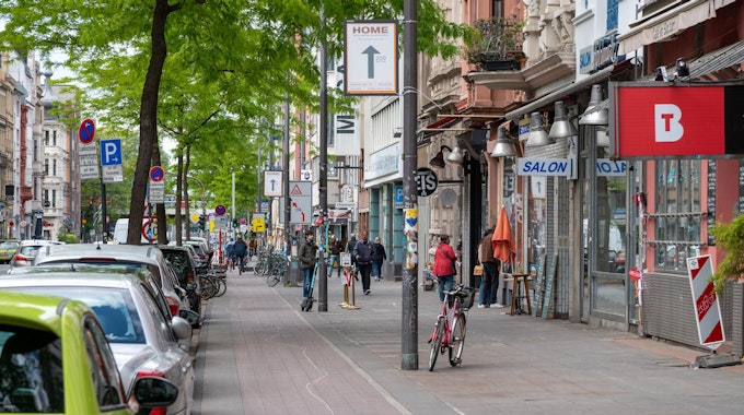 Passanten gehen auf der Aachener Straße in Köln.