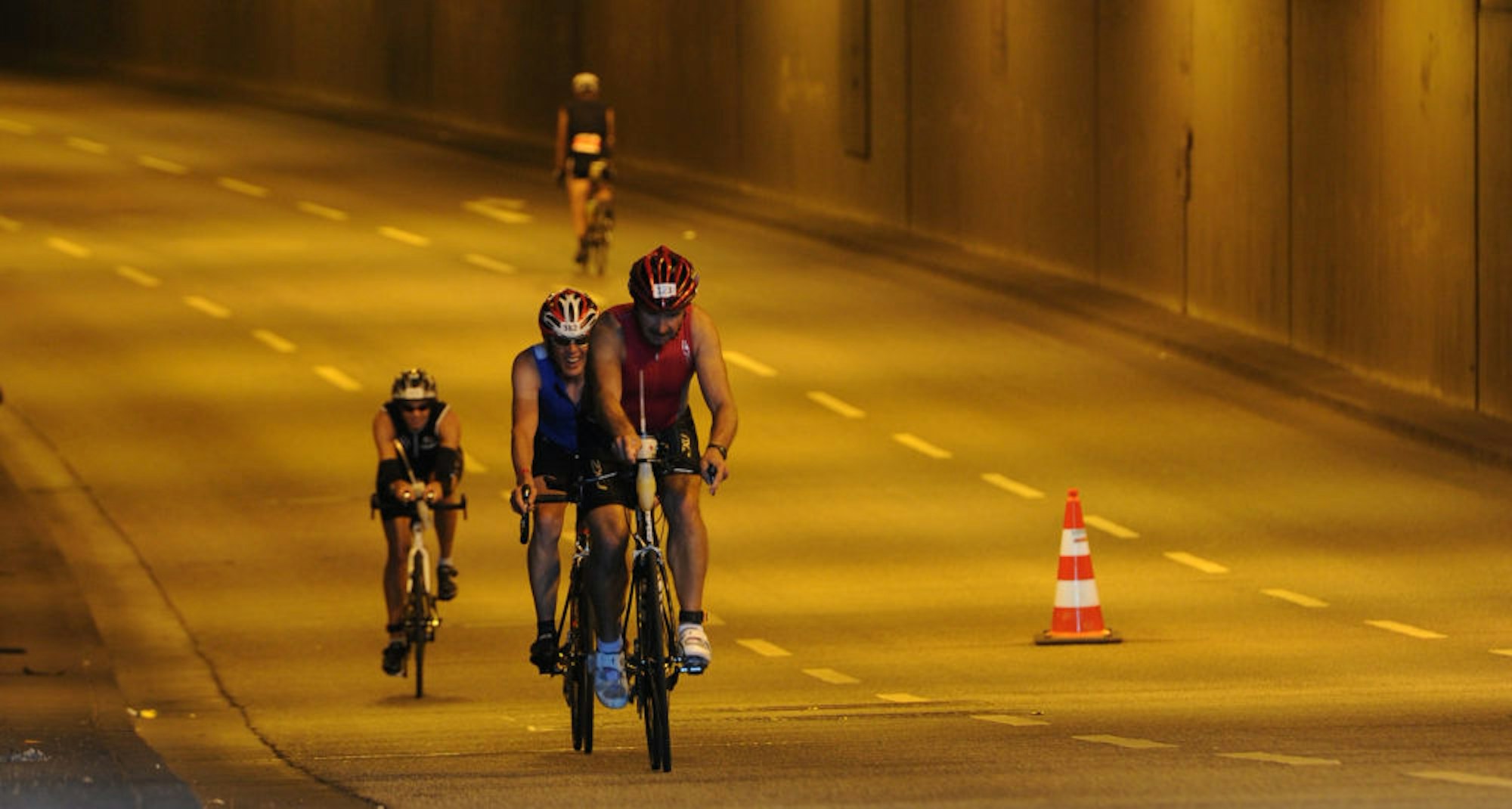 Triathleten auf ihren Rennrädern im Rheinufertunnel