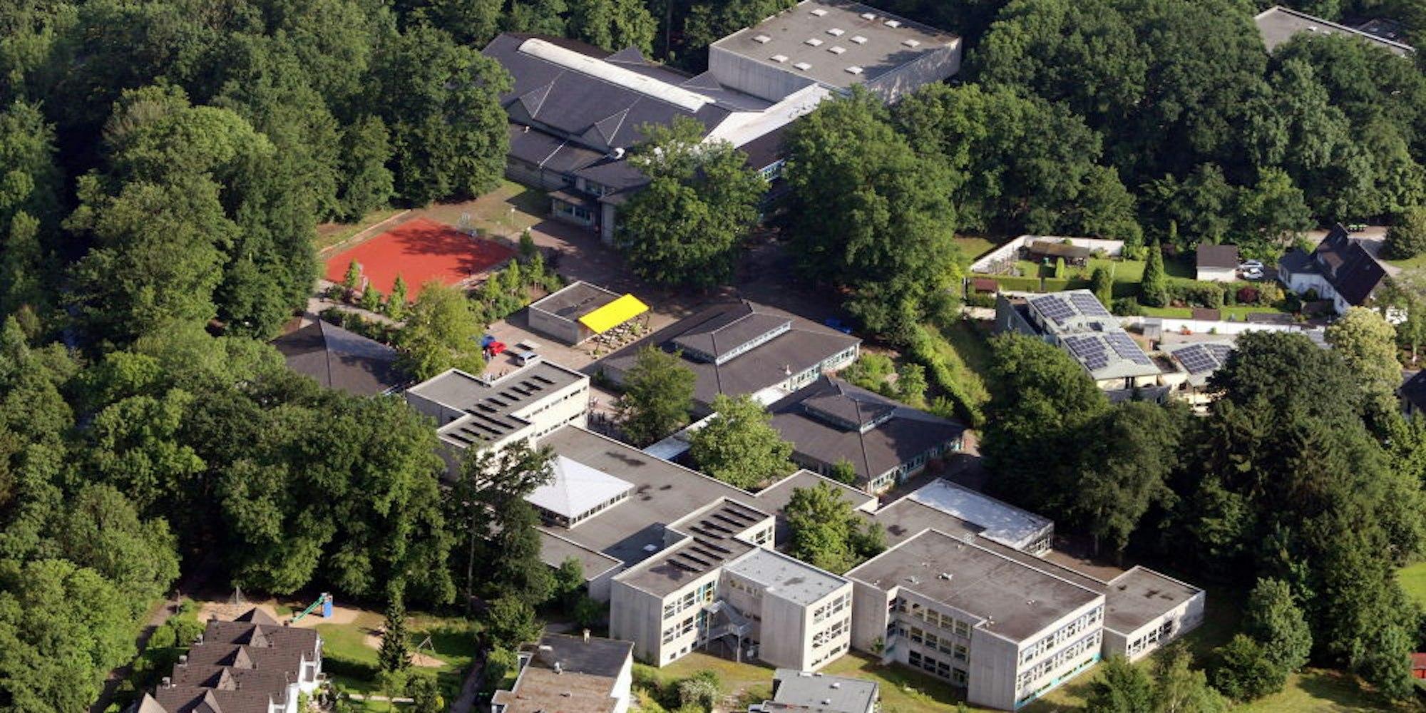 Die Grundschule liegt hinter dem Gebäudekomplex des Schulzentrums Odenthal.
