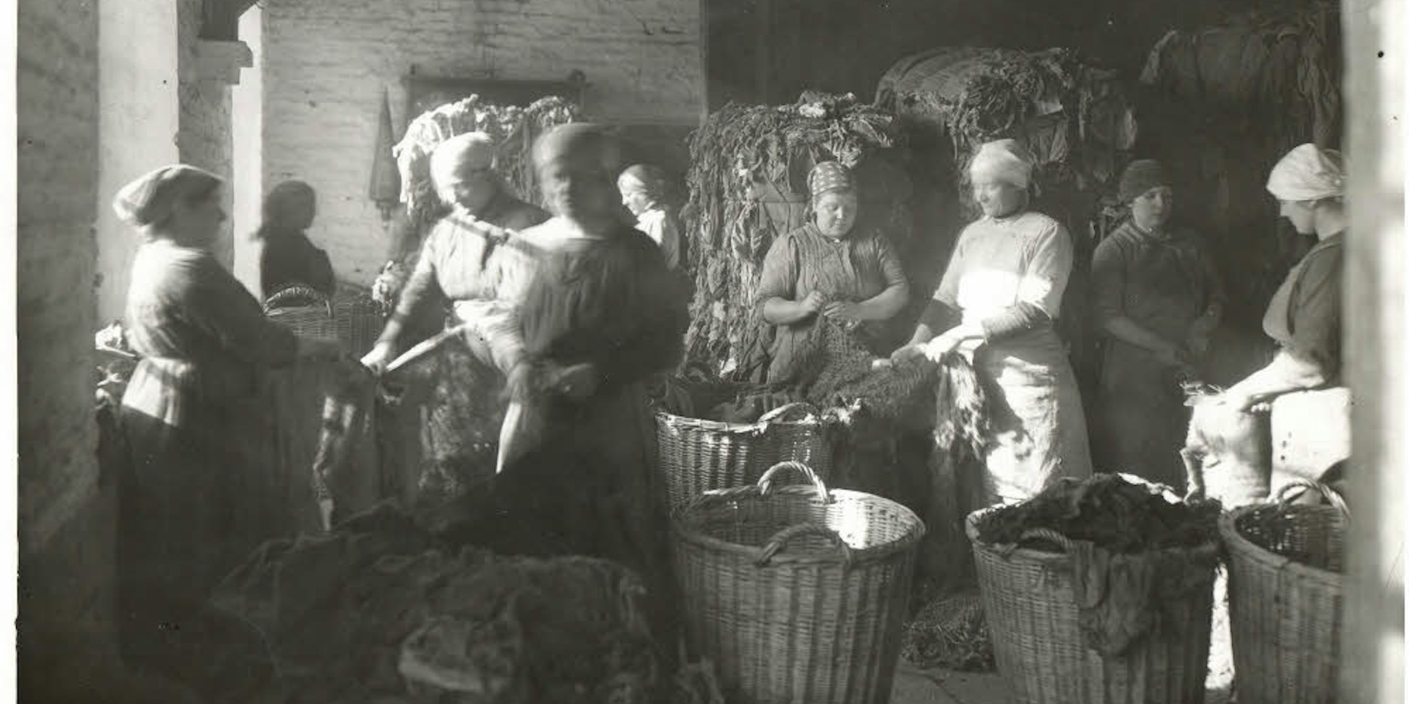 Lumpensortiererinnen bei der Arbeit. Lange Zeit waren alte Textilien der wichtigste Rohstoff für die Papierherstellung.