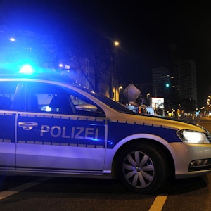 Ein Polizeiauto steht mit Blaulicht in Köln-Höhenhaus auf der Straße.