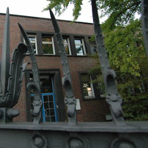 Das Gebäudeportal und die kunstvolle Metall-Einfriedung an der Vitalisstraße.