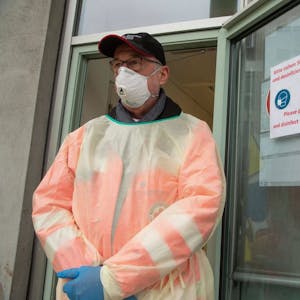 Ein Mann steht vor dem Klinikum Stuttgart - mit Schutzmaske und Schutzanzug, falls jemand mit dem Coronavirus eingeliefert wird.