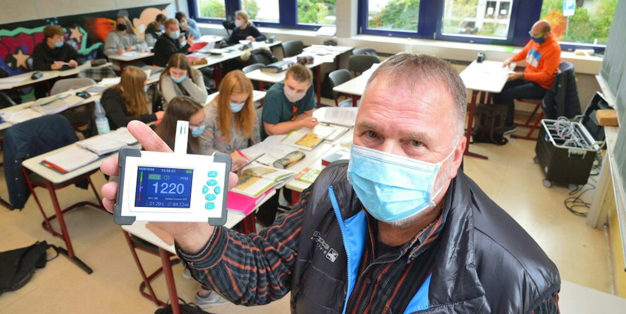 Der Kürtener Gesamtschuldirektor Klaus Schröder mit einem CO2-Messgerät, an seiner Schule seit Herbst im Einsatz.