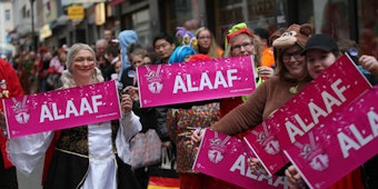 Mit „Alaaf“-Schildern standen diese Jecken im vergangenen Jahr an der Strecke des Kölner Rosenmontagszuges.