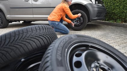 Eine Frau wechselt Reifen.