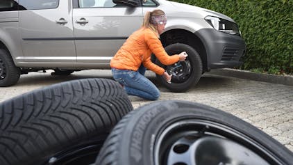 Eine Frau wechselt Reifen.