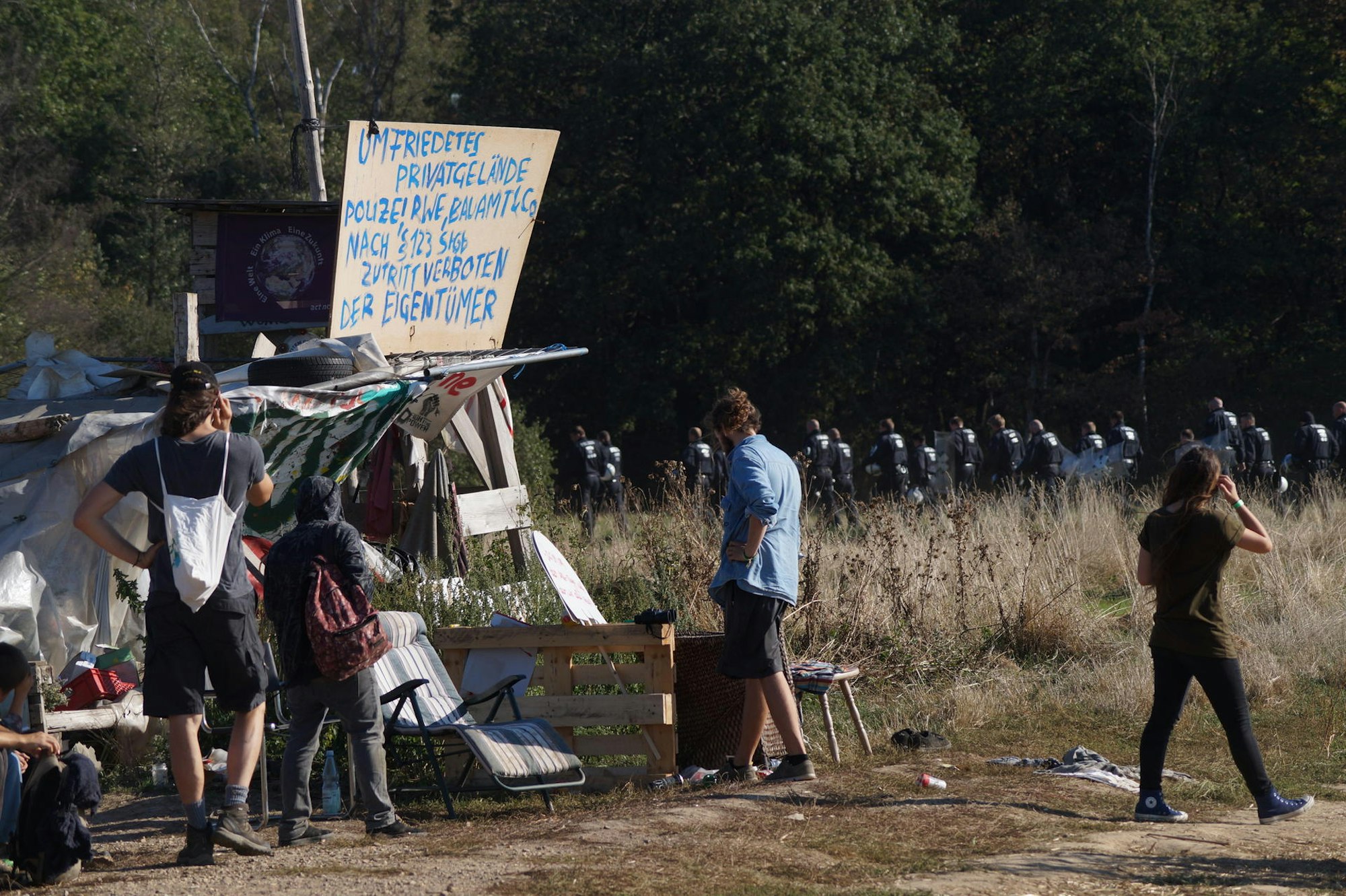Bewohner des Wiesencamps beobachten die Polizei dabei, wie diese das Camp am Hambacher Forst abriegelt.