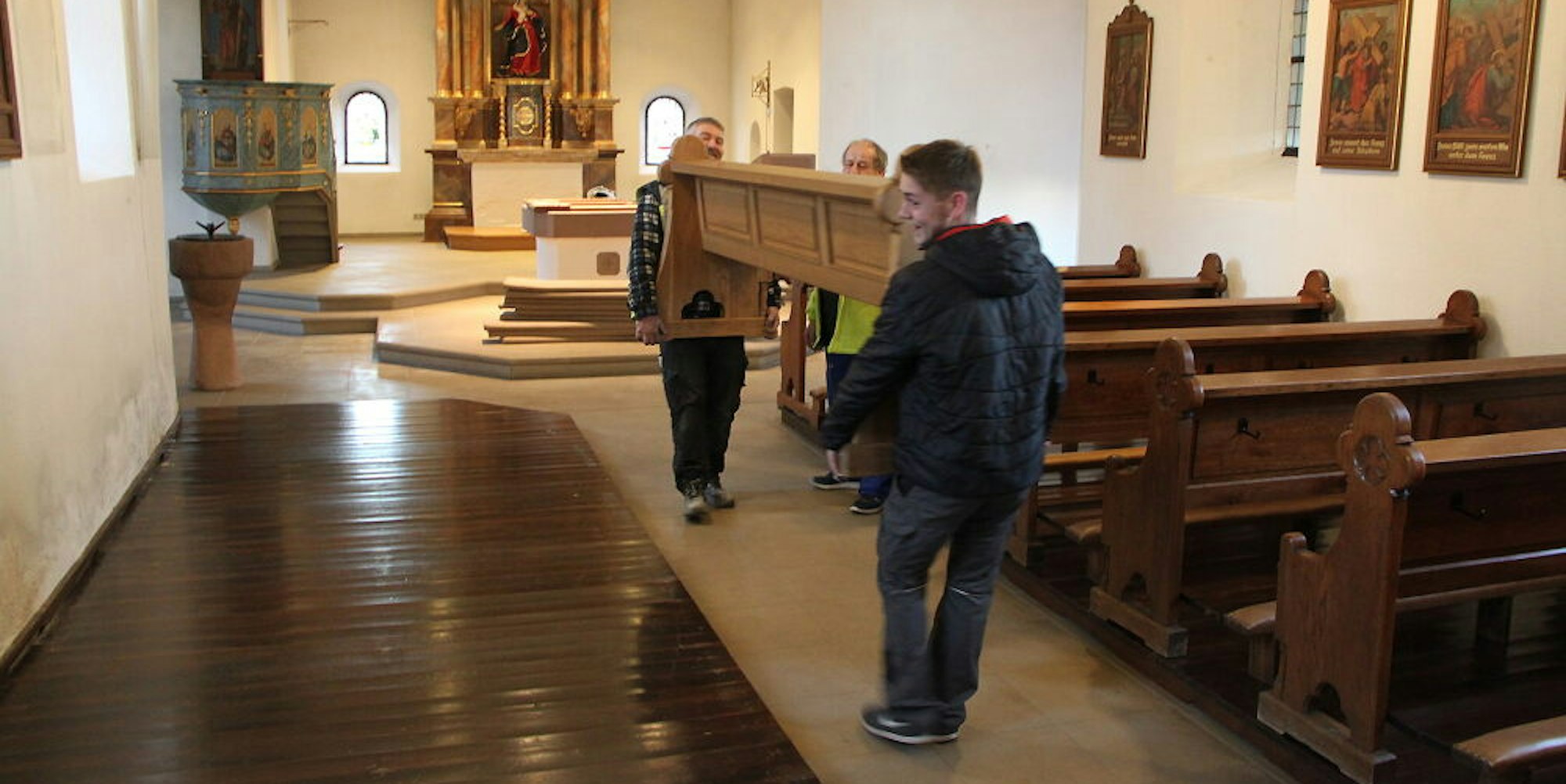 Die Bänke tragen Joachim Schröder (l.) und Tom Weber aus der Pfarrkirche.