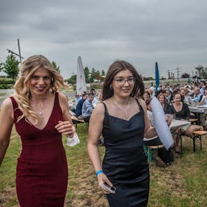 Emma Scharper (im roten Kleid) und Stefanie Urmersbach führen durch das Programm der Abi-Feier des Werner-Heisenberg-Gymnasiums im Neuland-Park.