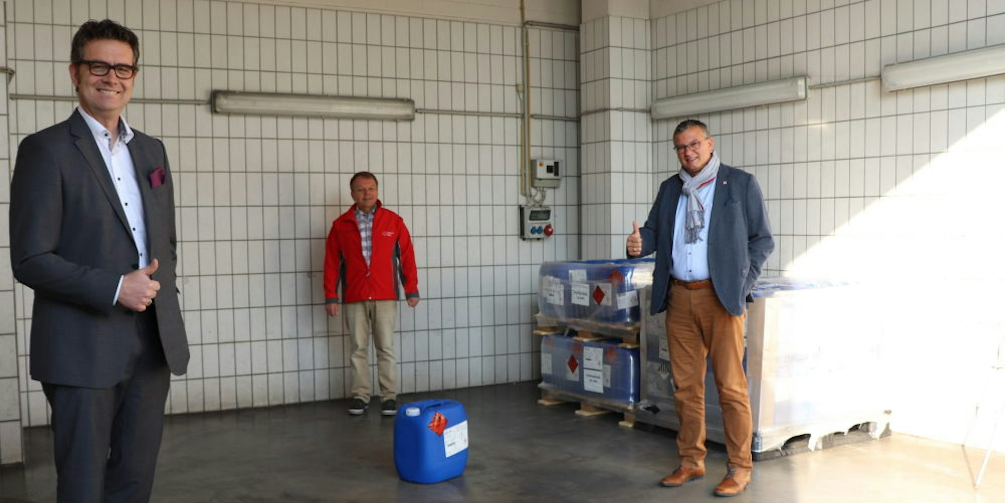 Standortleiter Arndt Selbach übergab Desinfektionsmittel an Gerd Röhrig (DRK) und Bürgermeister Stephan Vehreschild.