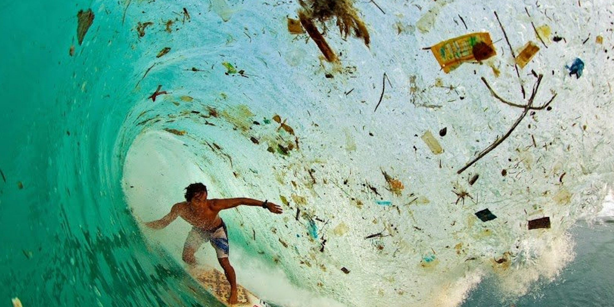Der indonesische Surfer Dede Surinaya reitet in einer Bucht von Java auf einer Welle voller Müll. Die Insel ist die am dichtesten besiedelte der Welt.