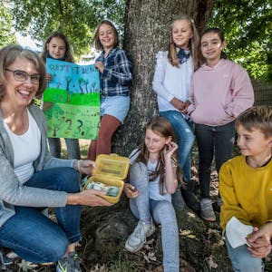 Die Drittklässlerin Emilia übergibt gemeinsam mit fünf Mitschülern die gesammelten Spenden an Sabine Strippel, Vereinsgründerin von „Bäume für Leverkusen“.