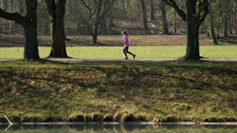Frau läuft durch einen Park