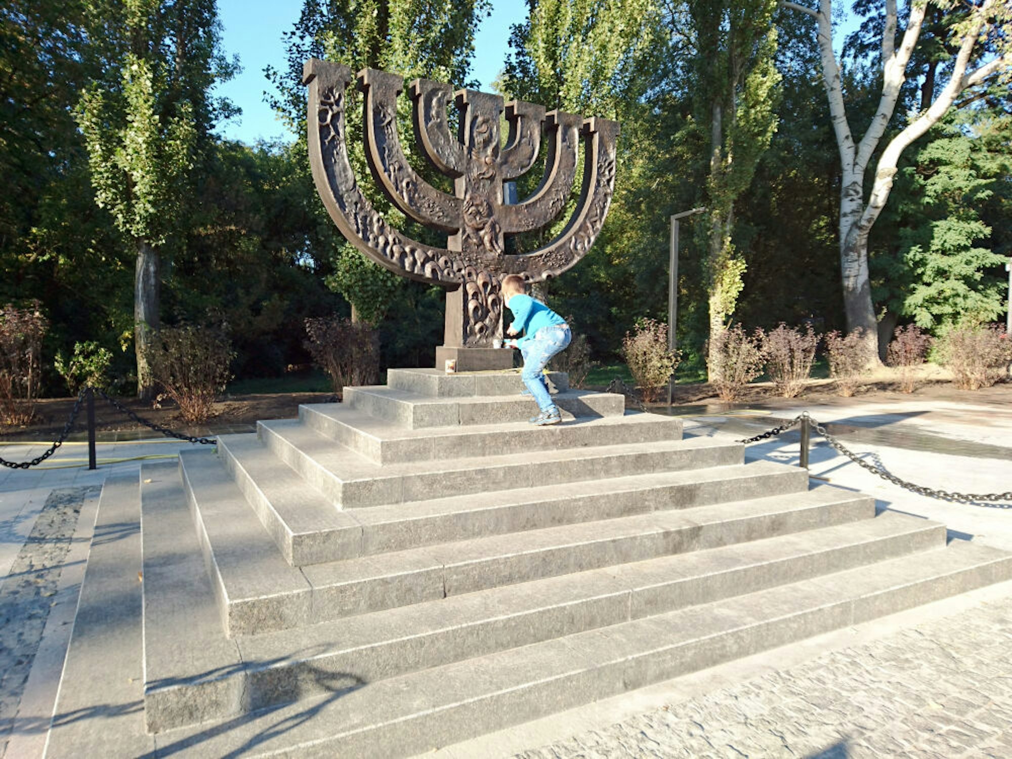 Ein Kind legt am Denkmal für die ermordeten Juden in Babi Jar Blumen nieder.