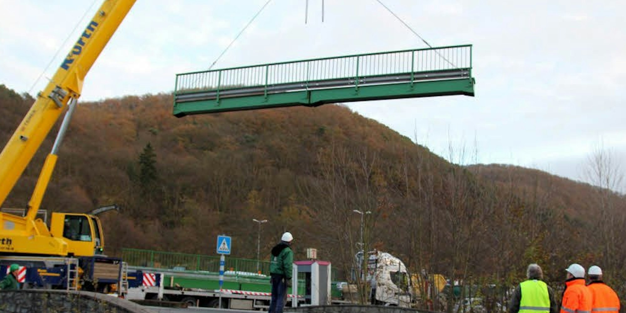 Geländer am Haken: Insgesamt neun Brückenelemente hievte der Kran der Firma Kurth auf die Brücke über die Erft.